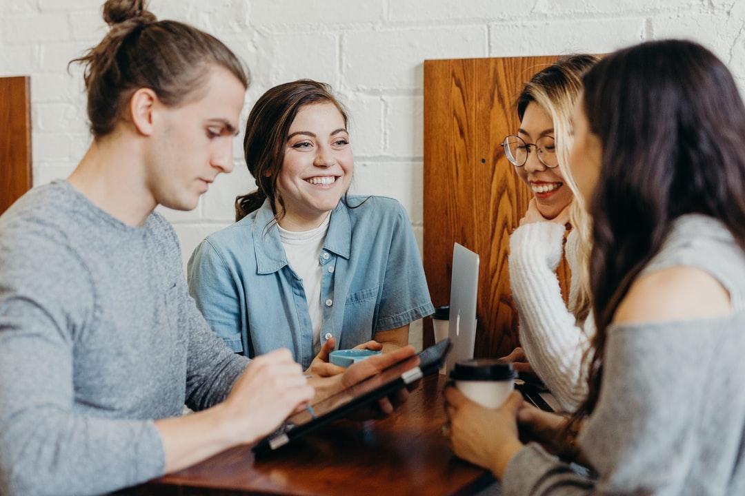 A team working and chatting at a coffee shop.